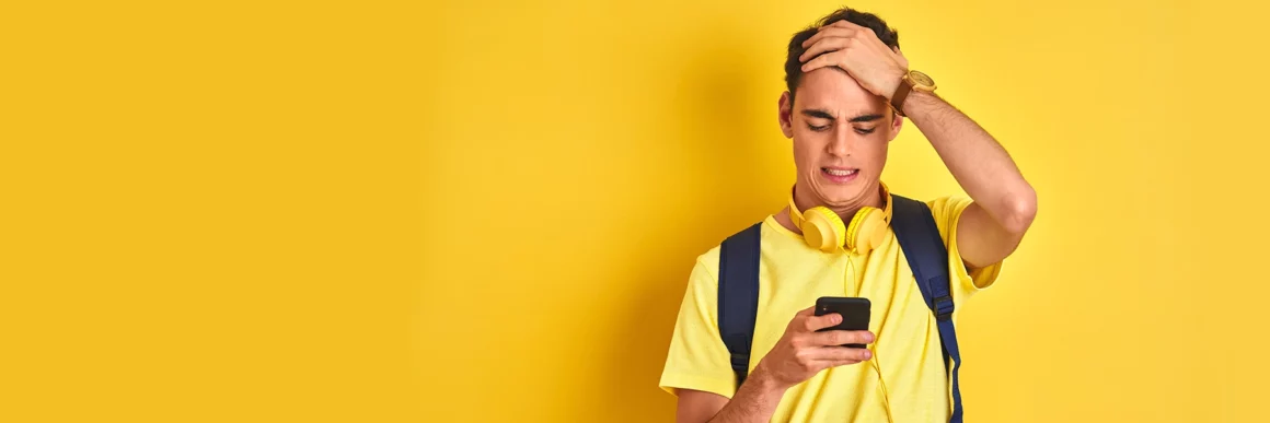 regretful teen with hand on head looking at phone