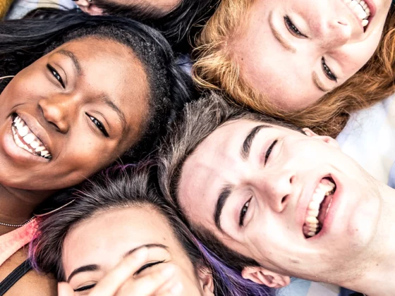 bright, smiling group of diverse teens laughing together