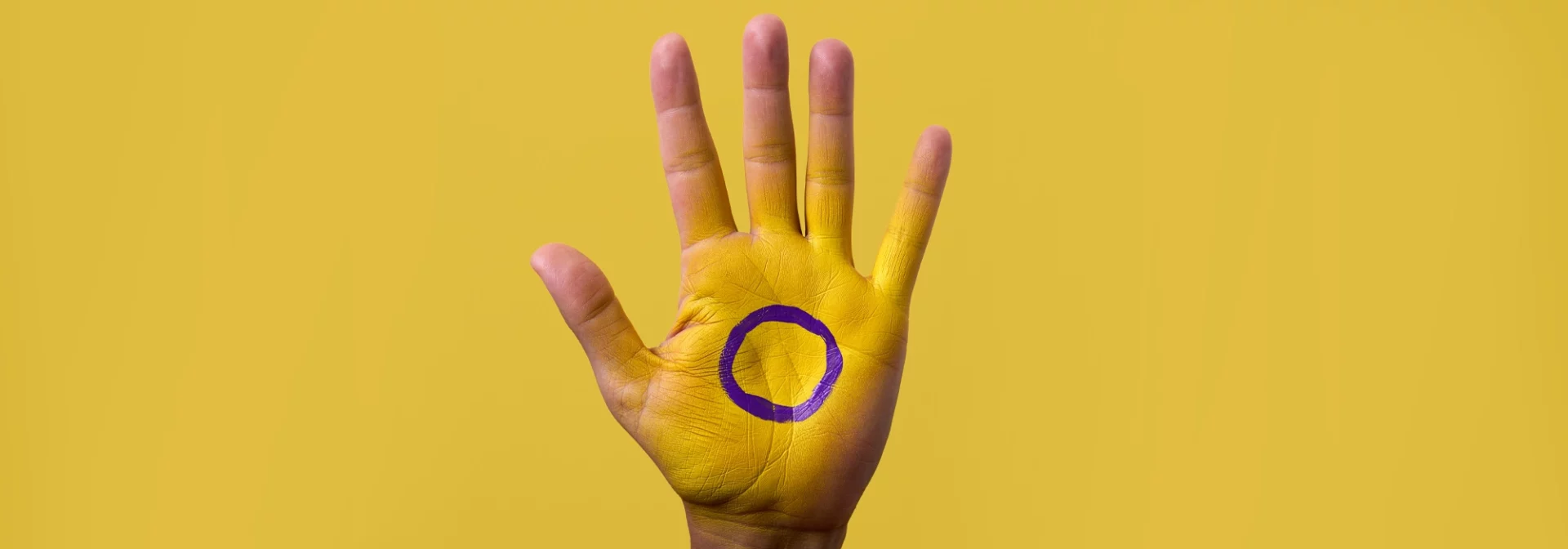 intersex flag and symbol on hand