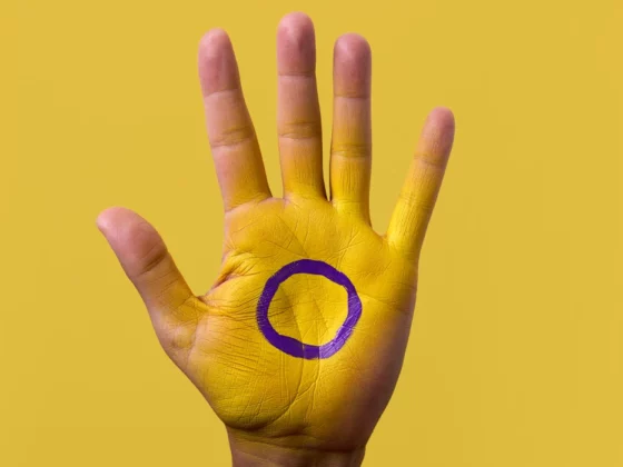 intersex flag and symbol on hand