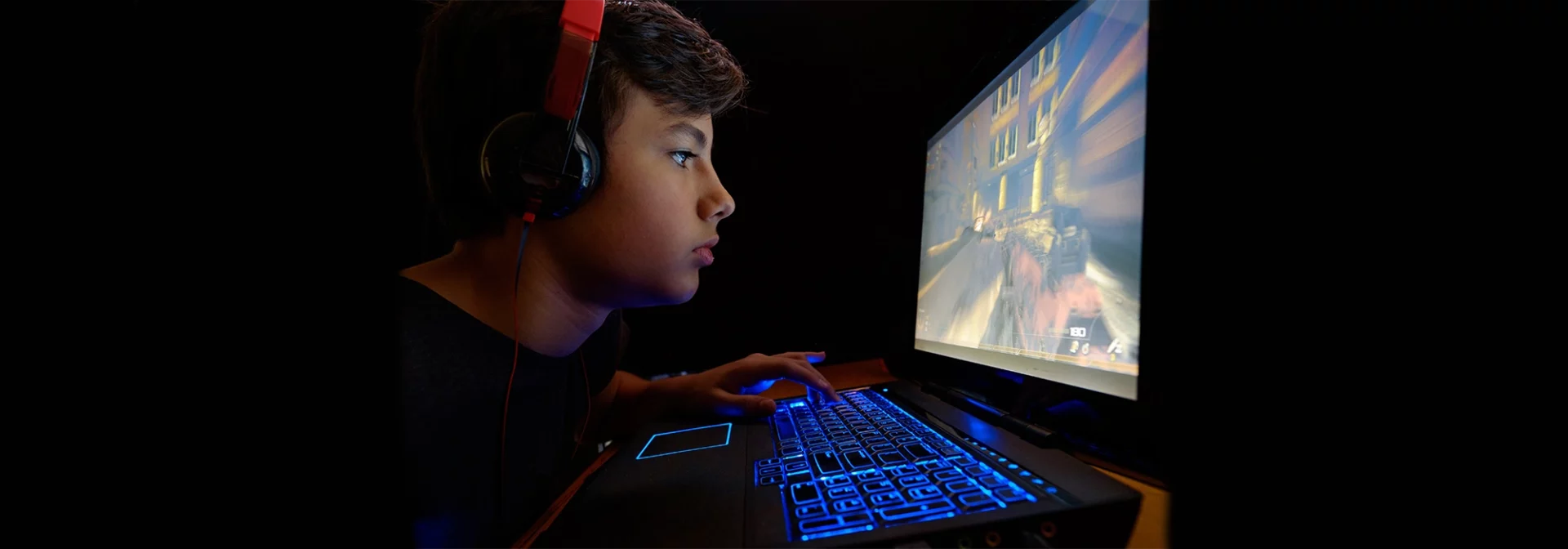 preteen boy on computer screen in room, teen headphones on, screen time for teens