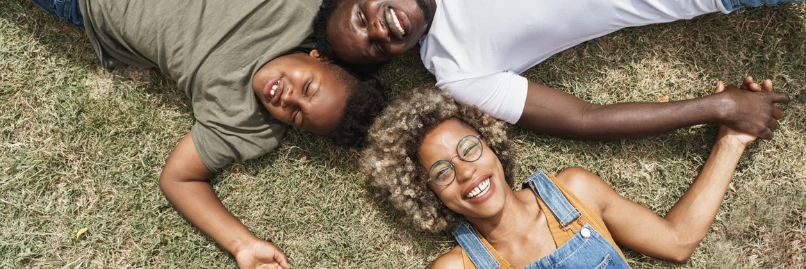 family bonding lying on the grass, happy young family