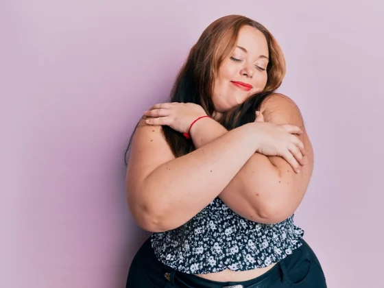 Plus size caucasian young woman wearing casual clothes hugging oneself happy and positive, smiling confident. self love and self care