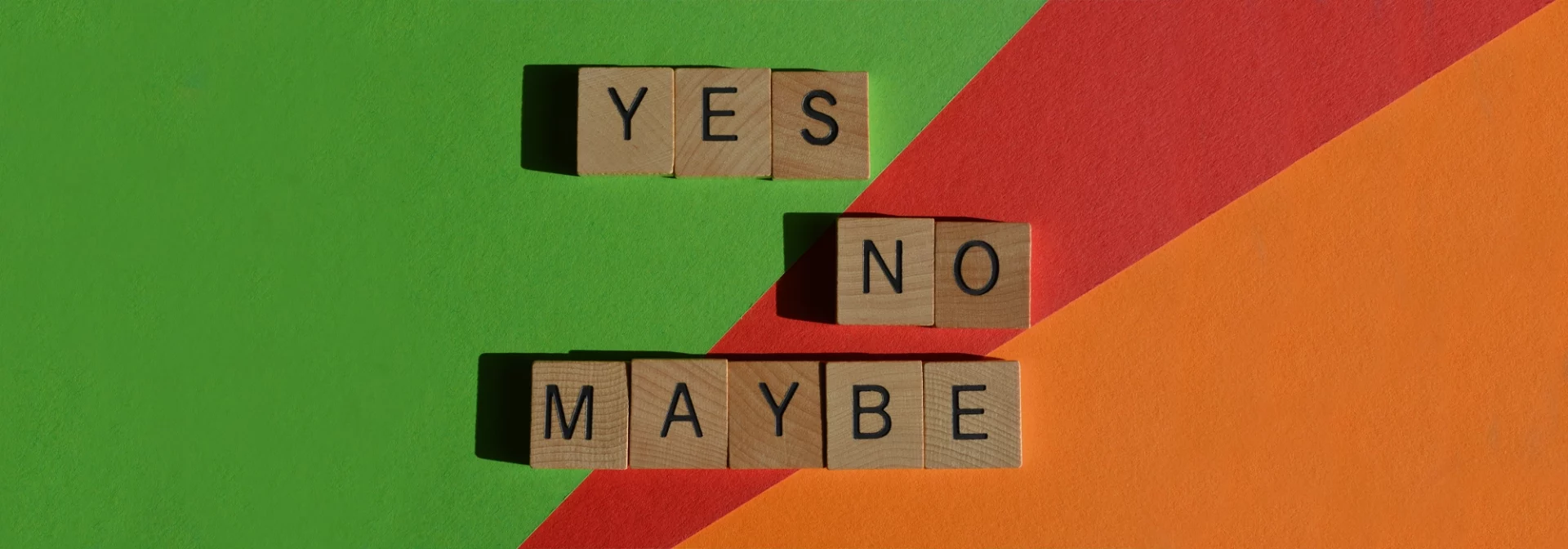 yes no maybe written in scrabble letters on colorful background