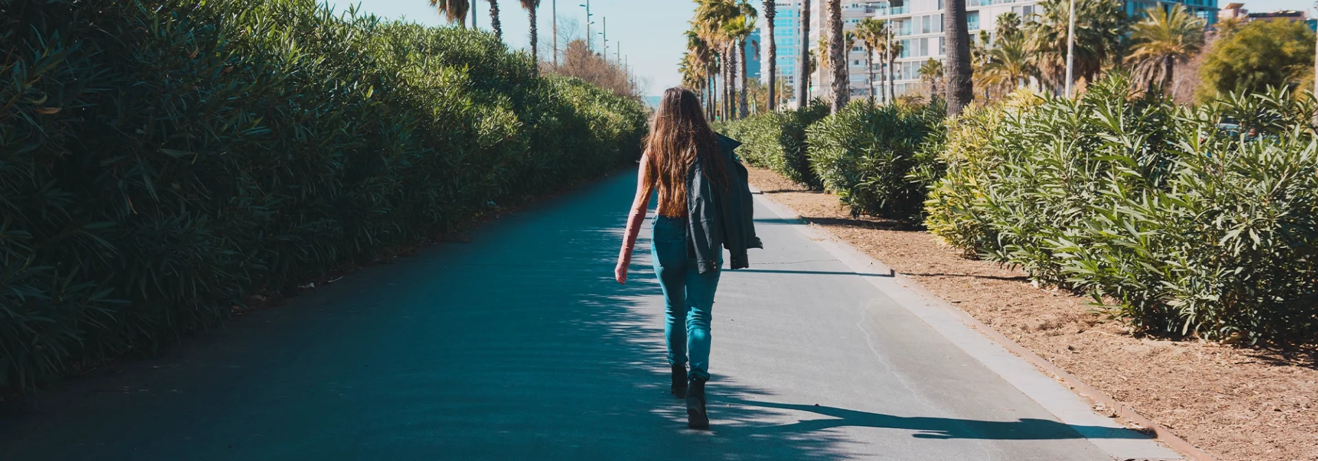 teen walking away on sidewalk outside, independent teenager
