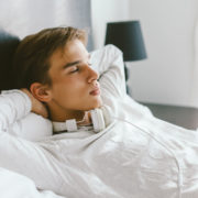 teenager relaxing on bed in his room