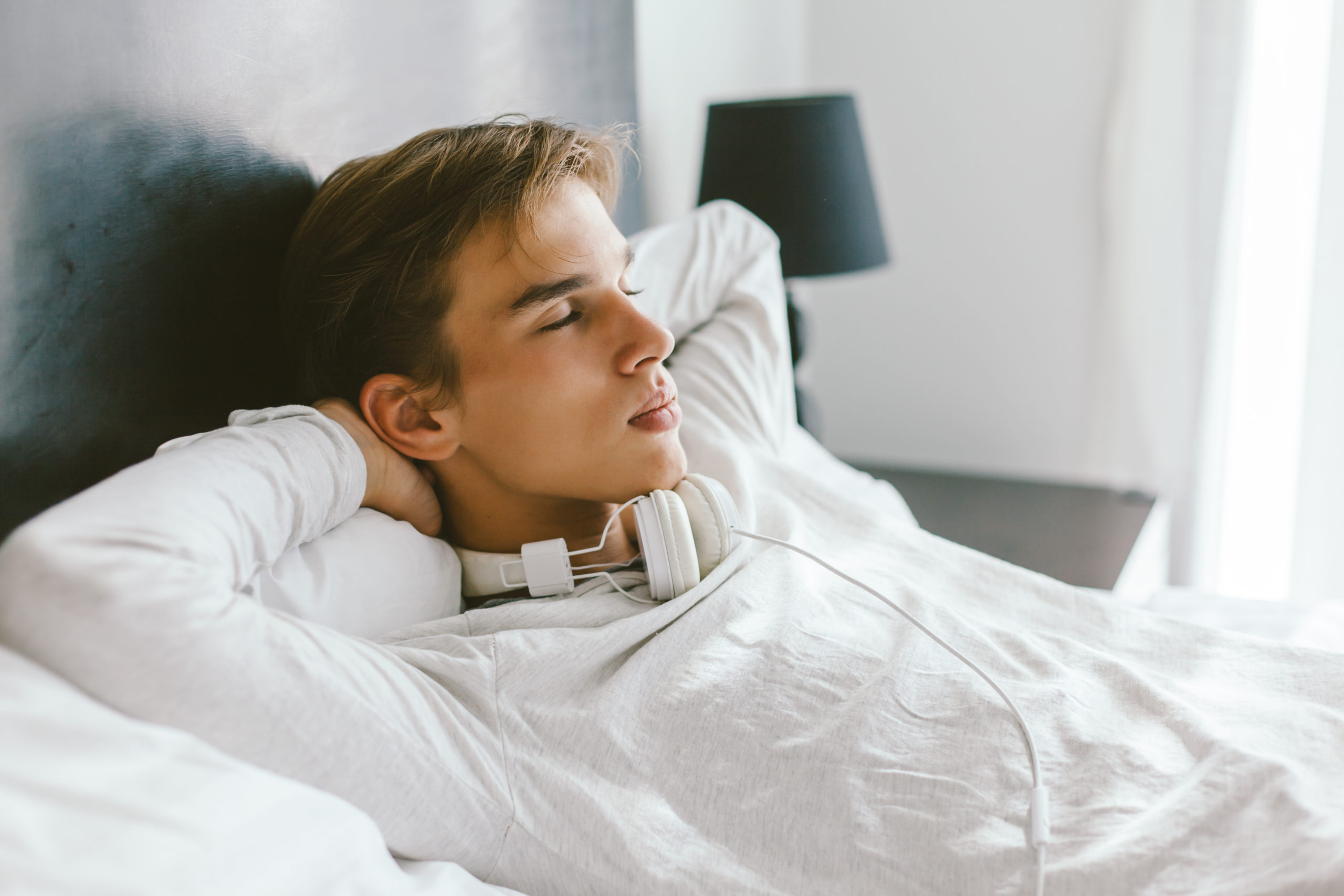 teenager relaxing on bed in his room