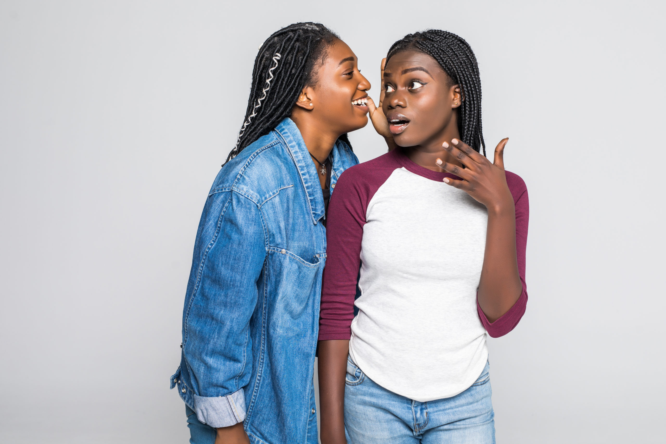 Portrait,Of,Two,Young,African,Women,Sharing,Secrets,Over,White