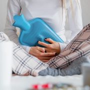 Woman using blue hot water bottle